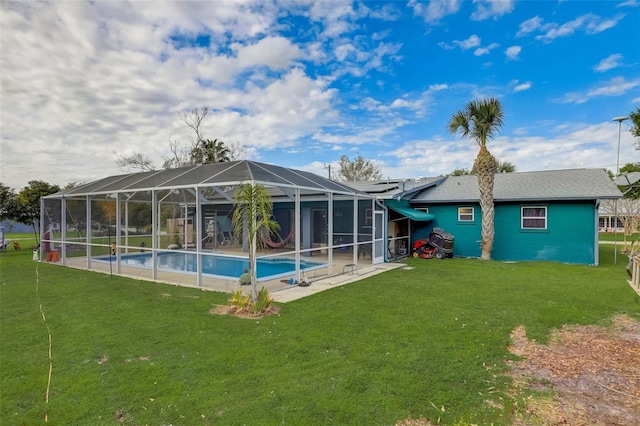 back of property with a lawn, a patio area, and glass enclosure