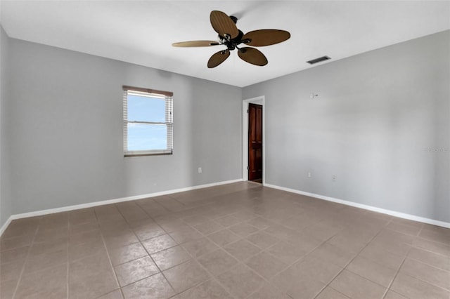 tiled spare room featuring ceiling fan