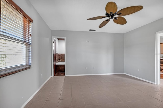 spare room featuring light tile floors and ceiling fan