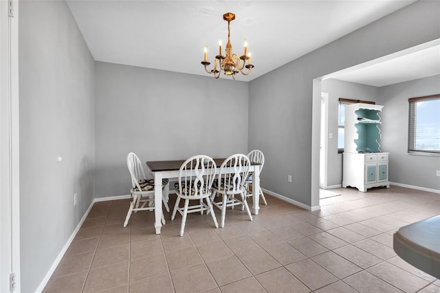 dining room featuring light tile floors and a chandelier