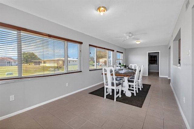 dining area featuring dark tile floors and ceiling fan