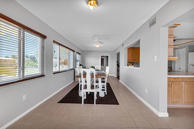 dining space with light tile floors and ceiling fan