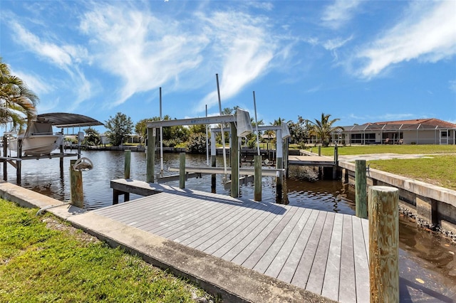 dock area featuring a water view, a lanai, and a lawn