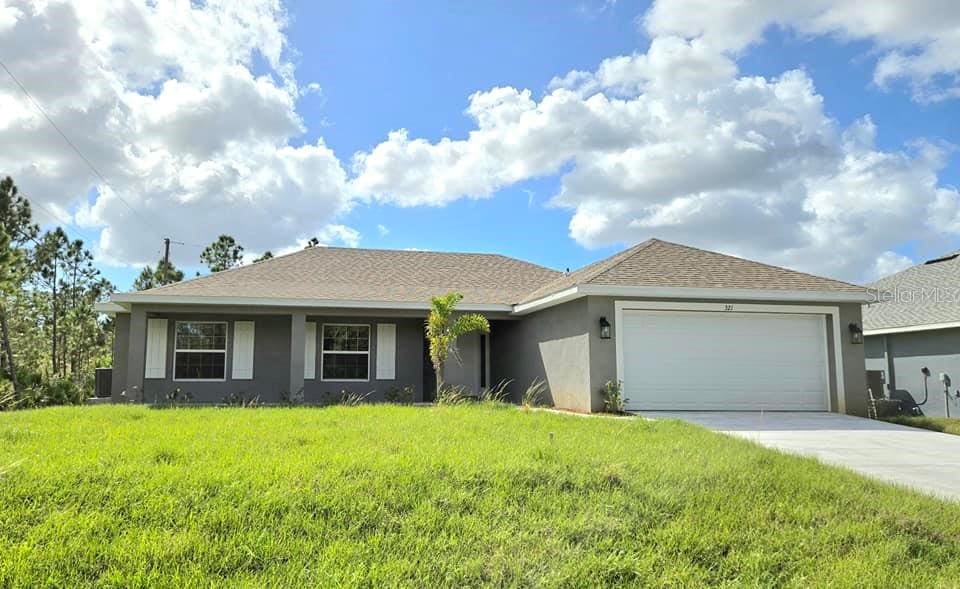 ranch-style home with a garage and a front yard