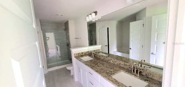 bathroom with vanity, toilet, an enclosed shower, and hardwood / wood-style floors