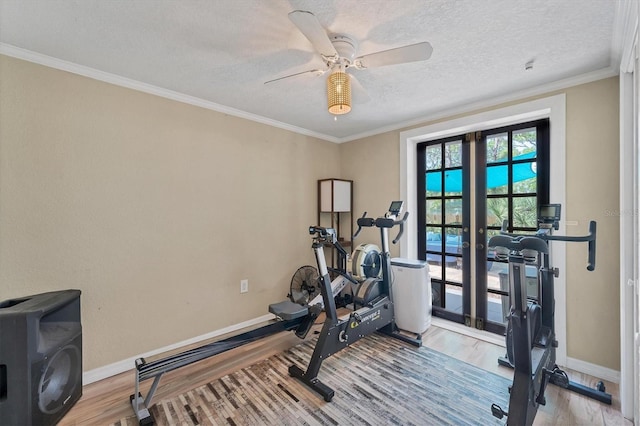 exercise area with light hardwood / wood-style floors, ornamental molding, a textured ceiling, and ceiling fan