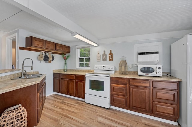 kitchen featuring white appliances, light stone counters, sink, and light hardwood / wood-style flooring