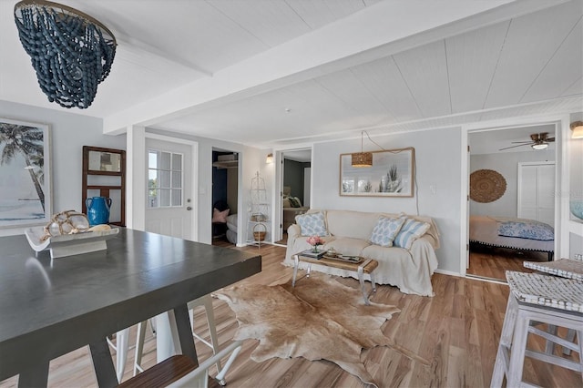 living room with beam ceiling, ceiling fan, and hardwood / wood-style flooring