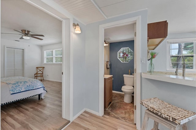 bathroom featuring wood-type flooring, toilet, ceiling fan, and vanity