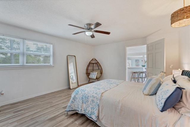 bedroom featuring a textured ceiling, ceiling fan, and light wood-type flooring