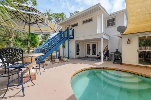 view of swimming pool featuring french doors and a patio