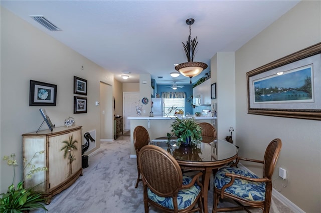 dining room with light carpet and ceiling fan