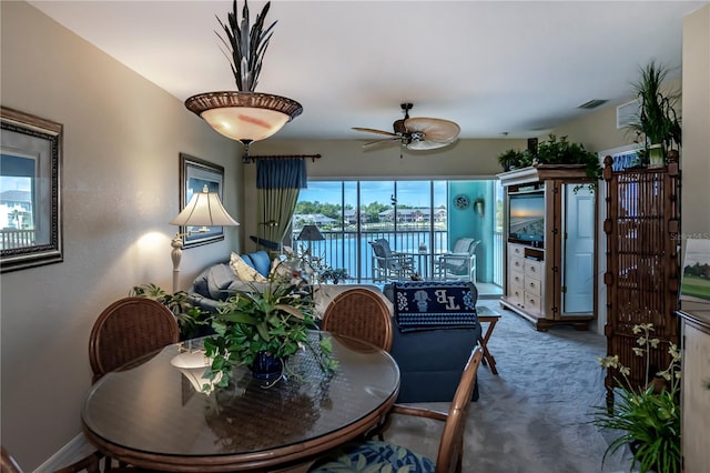 carpeted dining room featuring ceiling fan