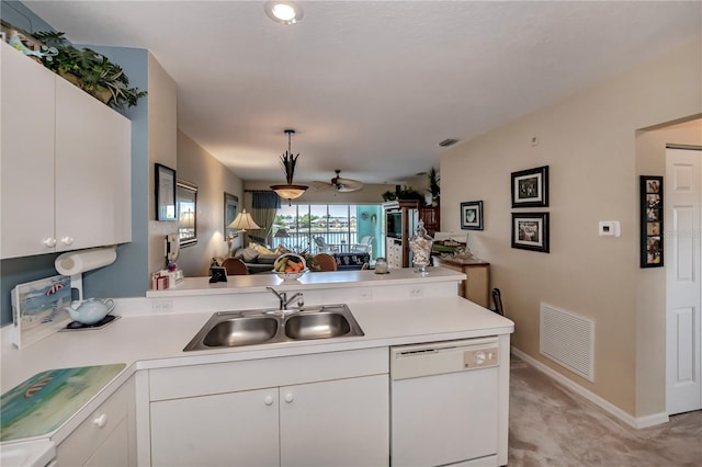 kitchen with light carpet, sink, dishwasher, white cabinetry, and kitchen peninsula