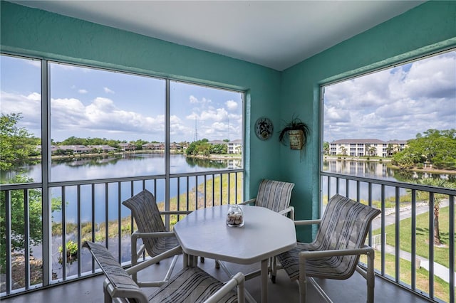 sunroom featuring a water view