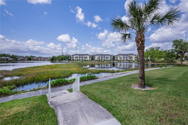 view of home's community featuring a water view and a lawn