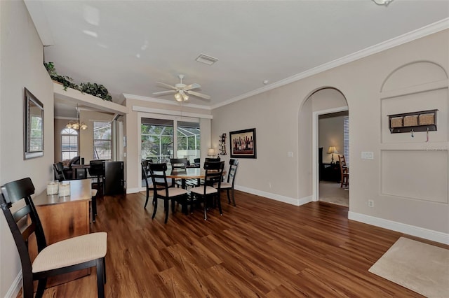 dining room with ornamental molding, ceiling fan with notable chandelier, and dark wood-type flooring