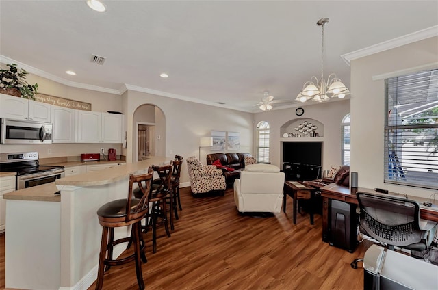 interior space featuring hanging light fixtures, white cabinets, light wood-type flooring, ceiling fan with notable chandelier, and stainless steel appliances