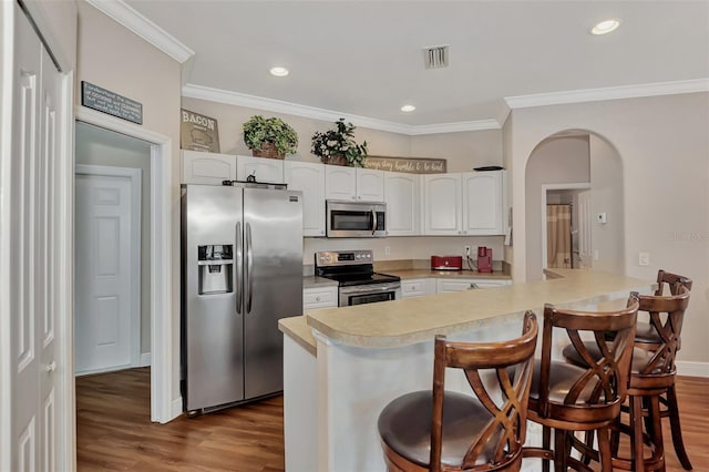 kitchen with appliances with stainless steel finishes, light wood-type flooring, white cabinetry, and a breakfast bar