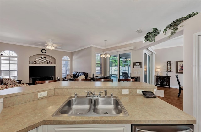 kitchen featuring decorative light fixtures, crown molding, ceiling fan with notable chandelier, hardwood / wood-style flooring, and sink