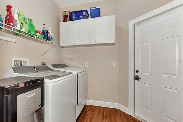 laundry room featuring wood-type flooring, washer and dryer, cabinets, and washer hookup