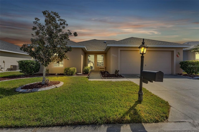 view of front of property with a garage and a yard