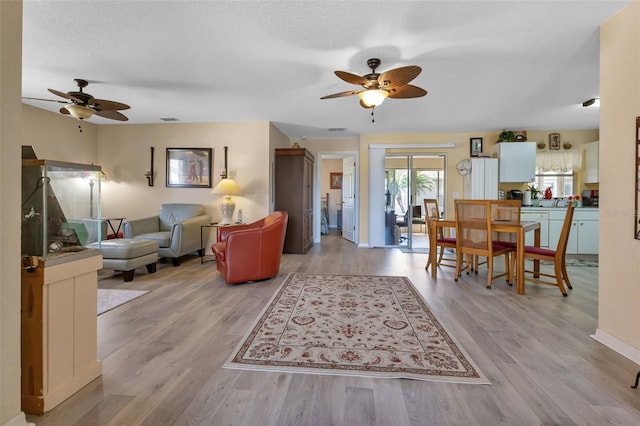 interior space with light hardwood / wood-style floors, ceiling fan, and a textured ceiling