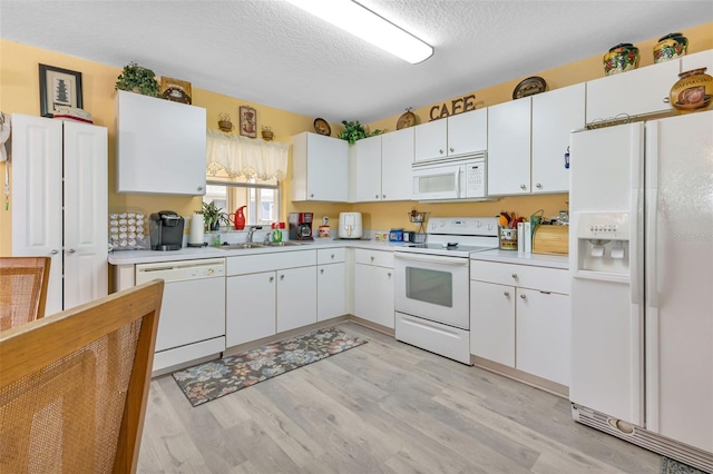 kitchen featuring white appliances, white cabinetry, a textured ceiling, and light hardwood / wood-style flooring