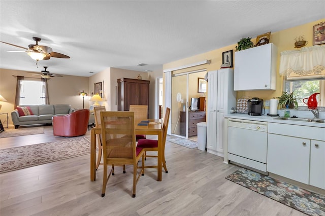 dining room featuring a textured ceiling, sink, ceiling fan, and light wood-type flooring