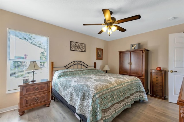 bedroom with multiple windows, ceiling fan, and light hardwood / wood-style flooring