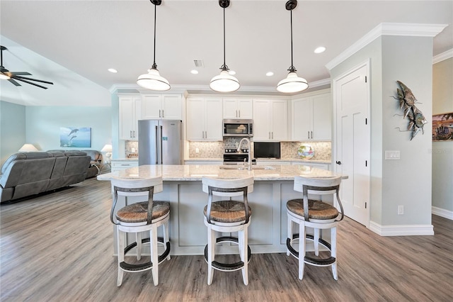 kitchen with white cabinetry, ceiling fan, appliances with stainless steel finishes, and light hardwood / wood-style flooring