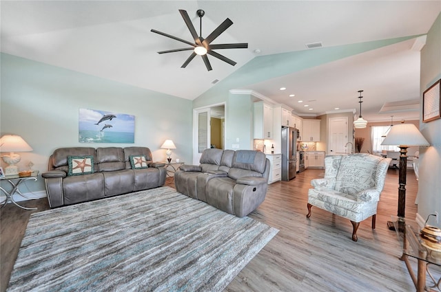 living room with light hardwood / wood-style floors, ceiling fan, and lofted ceiling