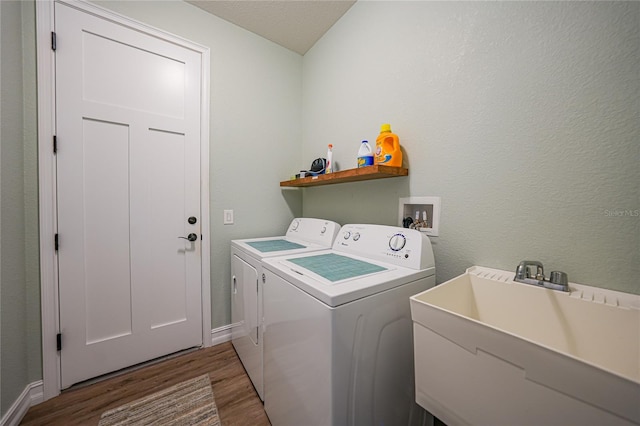 laundry room with hookup for a washing machine, independent washer and dryer, dark hardwood / wood-style floors, and sink