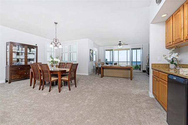 dining room with ceiling fan with notable chandelier, light colored carpet, and a healthy amount of sunlight