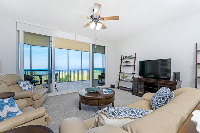 carpeted living room featuring floor to ceiling windows, a water view, and ceiling fan