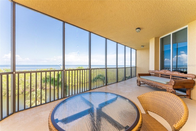 sunroom featuring a water view and a wealth of natural light