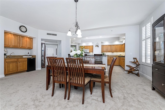 dining room featuring a healthy amount of sunlight, light carpet, and a chandelier