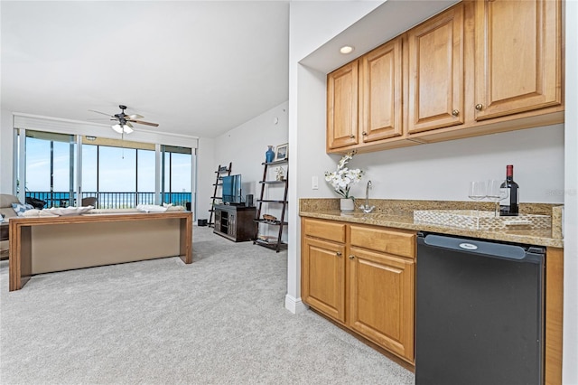 kitchen with light stone countertops, ceiling fan, dishwasher, and light colored carpet