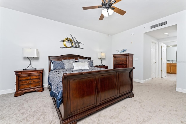 bedroom with ensuite bath, ceiling fan, and light carpet