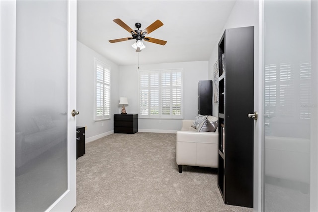 interior space with ceiling fan and light carpet