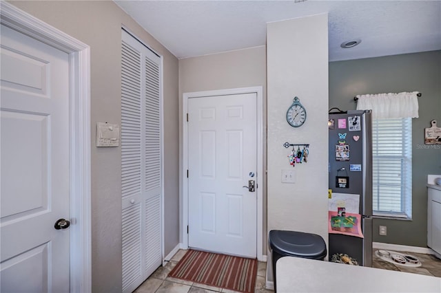 foyer entrance with light tile flooring