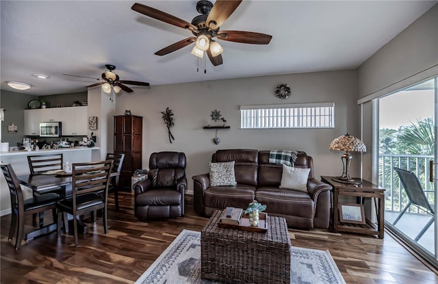 living room with ceiling fan and dark wood-type flooring