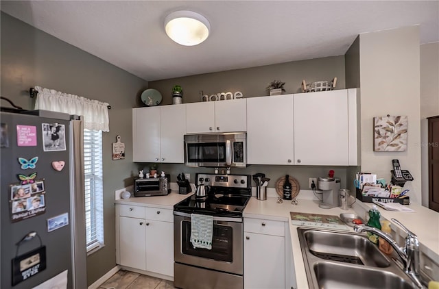 kitchen with sink, plenty of natural light, white cabinetry, and stainless steel appliances