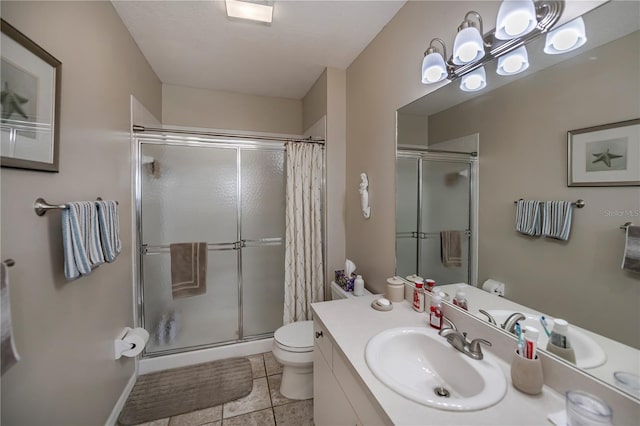 bathroom with walk in shower, large vanity, tile floors, and toilet