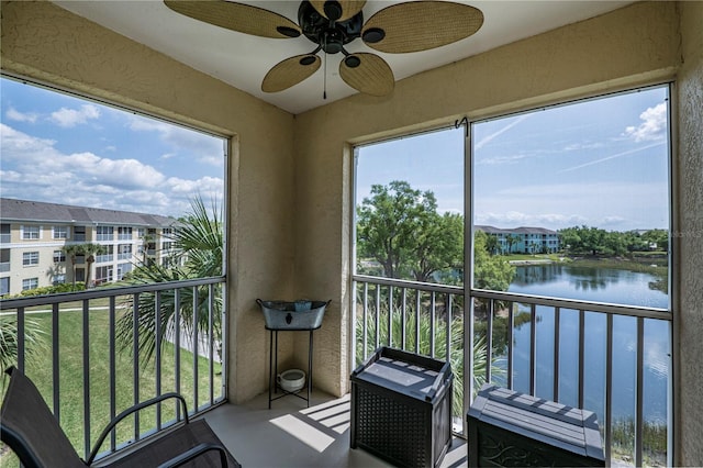 balcony featuring ceiling fan and a water view