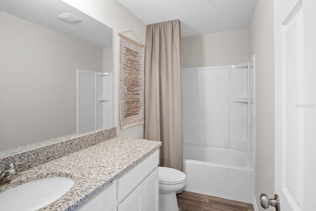 full bathroom featuring a textured ceiling, hardwood / wood-style flooring, shower / bathtub combination with curtain, vanity, and toilet