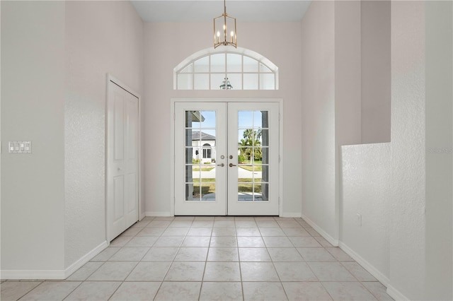 doorway to outside featuring an inviting chandelier, light tile patterned floors, and french doors