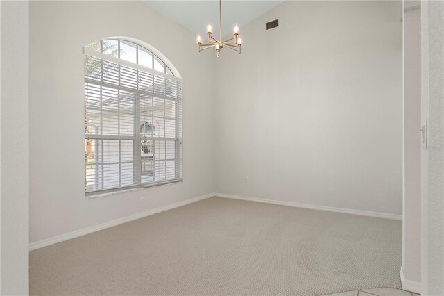 empty room with carpet floors, lofted ceiling, and a notable chandelier