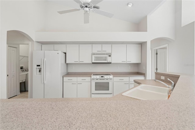 kitchen featuring white appliances, ceiling fan, sink, high vaulted ceiling, and white cabinetry