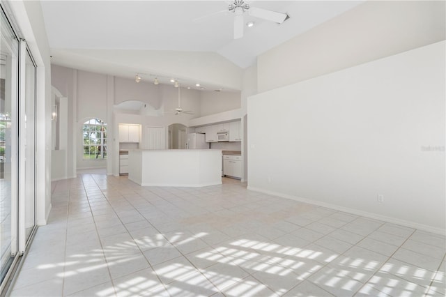 unfurnished living room with high vaulted ceiling, ceiling fan, and light tile patterned flooring